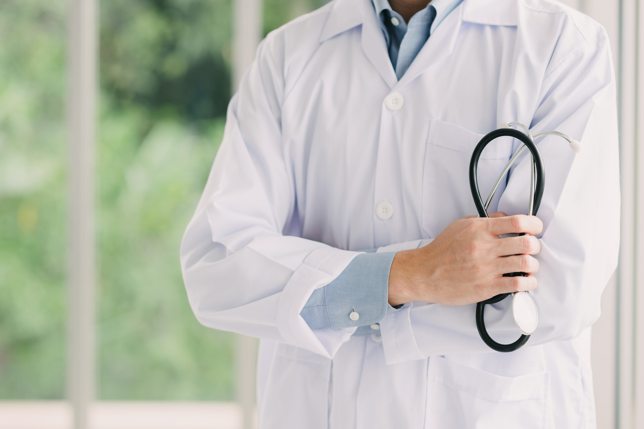 doctor with arms crossed holding stethoscope
